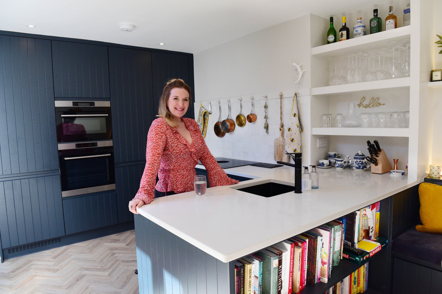 Jenny at a navy kitchen island with open shelving