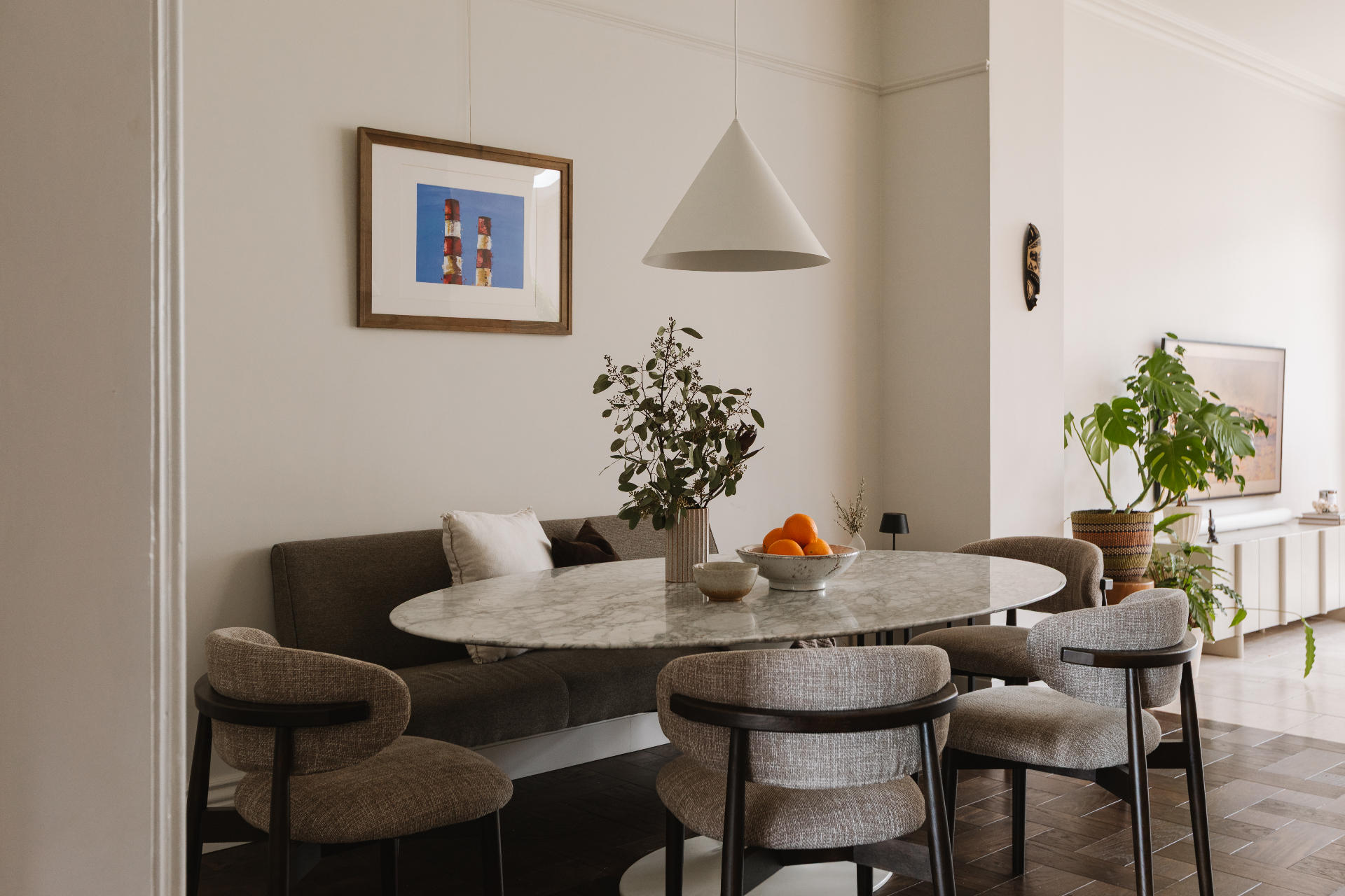 Dining nook with marble oval table and upholstered chairs